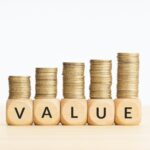 Value word on wooden blocks and rising stacked coins